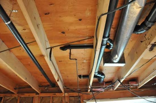 Canalisations apparentes sous un plafond en bois